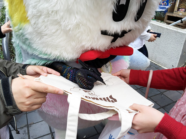 しもっきートートを買ってくれた人に直筆サインをするしもっきー。相変わらず器用だなぁ