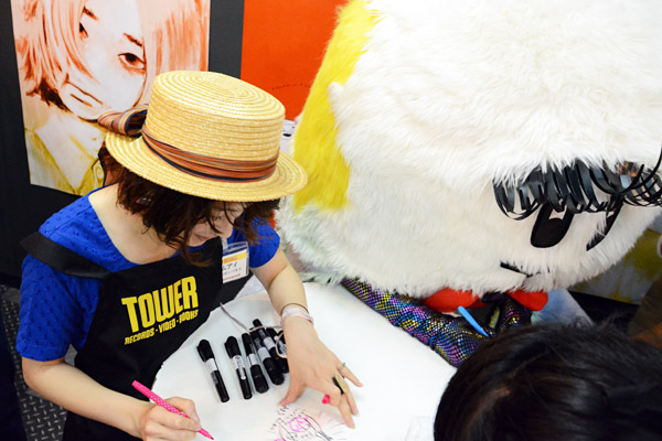 しもっきーの似顔絵を採点するコムアイさん、もちろんサインも入れてくれます