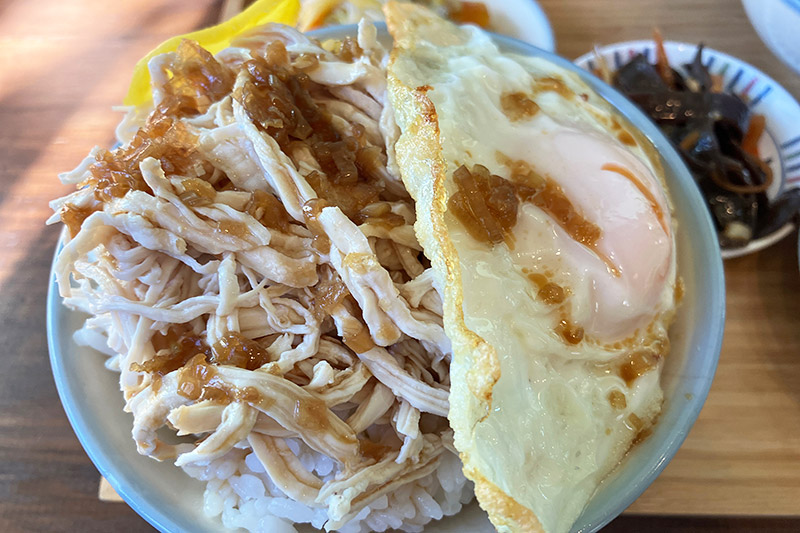 細かく割いた鶏肉に鶏汁を使ったタレがかかり、目玉焼きがのったジーロー飯