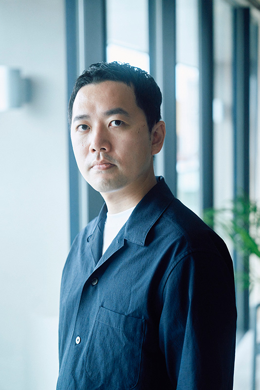岩井圭也(いわい・けいや)
作家。1987年生まれ。大阪府出身。2018年、「永遠についての証明」で第9回野性時代フロンティア文学賞を受賞しデビュー。著書に『夏の陰』『文身』『最後の鑑定人』『付き添うひと』などがある。(撮影・橋本龍二)
岩井さんのコメント
この取り組みは単なるコラボレーションではなく、小説という表現の可能性を切り拓く試みです。沿線各地との深いつながりを持つ京王電鉄さん、豊かなコンテンツ開発力を有する休日ハックさん、そして小説家である私が出会うことでどんな色の火花が散らされるのか。ぜひ、その「現場」を目撃してください。
