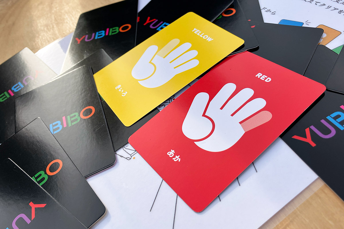 参加者に色を割り当て、2枚のカードを引いて示された指で棒を支えます